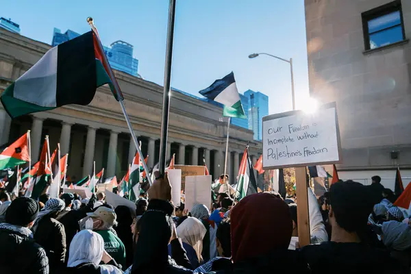 Filistinlilerin Gazze 'deki İsrail saldırısına karşı Toronto' da savaş karşıtı yürüyüş. İsrail-HAMAS savaşını barışçıl bir şekilde protesto ediyor. Protestocular bayrak sallıyor. Filistin soykırımı.