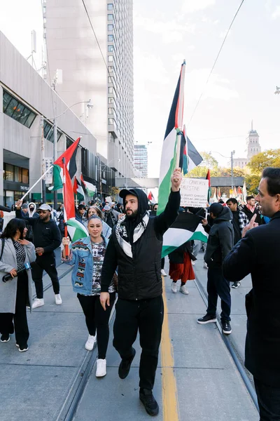 stock image Anti-war march in Toronto by Palestinians against Israels aggression in Gaza. Citys peaceful protest against Israel-HAMAS war. Protesters wave flags against. Palestinian genocide.