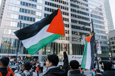Filistinlilerin Gazze 'deki İsrail saldırısına karşı Toronto' da savaş karşıtı yürüyüş. İsrail-HAMAS savaşını barışçıl bir şekilde protesto ediyor. Protestocular bayrak sallıyor. Filistin soykırımı.