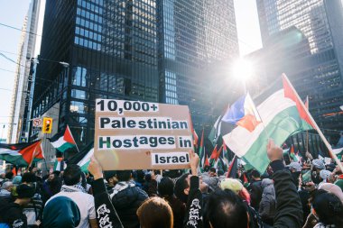 Filistinlilerin Gazze 'deki İsrail saldırısına karşı Toronto' da savaş karşıtı yürüyüş. İsrail-HAMAS savaşını barışçıl bir şekilde protesto ediyor. Protestocular bayrak sallıyor. Filistin soykırımı.