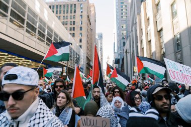 Filistinlilerin Gazze 'deki İsrail saldırısına karşı Toronto' da savaş karşıtı yürüyüş. İsrail-HAMAS savaşını barışçıl bir şekilde protesto ediyor. Protestocular bayrak sallıyor. Filistin soykırımı.