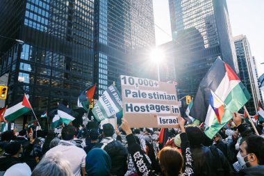 Filistinlilerin Gazze 'deki İsrail saldırısına karşı Toronto' da savaş karşıtı yürüyüş. İsrail-HAMAS savaşını barışçıl bir şekilde protesto ediyor. Protestocular bayrak sallıyor. Filistin soykırımı.