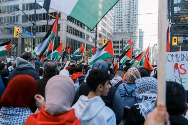 Filistinlilerin Gazze 'deki İsrail saldırısına karşı Toronto' da savaş karşıtı yürüyüş. İsrail-HAMAS savaşını barışçıl bir şekilde protesto ediyor. Protestocular bayrak sallıyor. Filistin soykırımı.