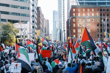 Filistinlilerin Gazze 'deki İsrail saldırısına karşı Toronto' da savaş karşıtı yürüyüş. İsrail-HAMAS savaşını barışçıl bir şekilde protesto ediyor. Protestocular bayrak sallıyor. Filistin soykırımı.