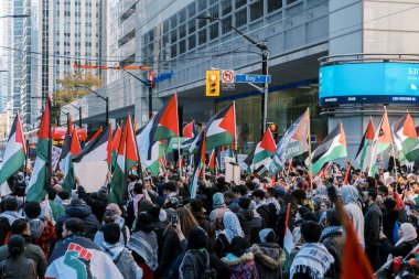 Filistinlilerin Gazze 'deki İsrail saldırısına karşı Toronto' da savaş karşıtı yürüyüş. İsrail-HAMAS savaşını barışçıl bir şekilde protesto ediyor. Protestocular bayrak sallıyor. Filistin soykırımı.