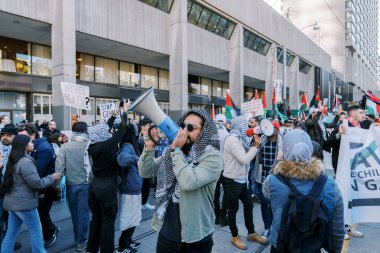 Filistinlilerin Gazze 'deki İsrail saldırısına karşı Toronto' da savaş karşıtı yürüyüş. İsrail-HAMAS savaşını barışçıl bir şekilde protesto ediyor. Protestocular bayrak sallıyor. Filistin soykırımı.