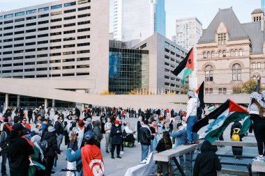 Filistinlilerin Gazze 'deki İsrail saldırısına karşı Toronto' da savaş karşıtı yürüyüş. İsrail-HAMAS savaşını barışçıl bir şekilde protesto ediyor. Protestocular bayrak sallıyor. Filistin soykırımı.