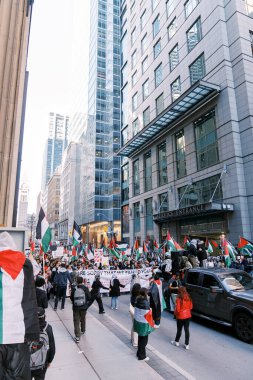 Filistinlilerin Gazze 'deki İsrail saldırısına karşı Toronto' da savaş karşıtı yürüyüş. İsrail-HAMAS savaşını barışçıl bir şekilde protesto ediyor. Protestocular bayrak sallıyor. Filistin soykırımı.