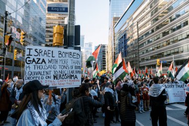 Filistinlilerin Gazze 'deki İsrail saldırısına karşı Toronto' da savaş karşıtı yürüyüş. İsrail-HAMAS savaşını barışçıl bir şekilde protesto ediyor. Protestocular bayrak sallıyor. Filistin soykırımı.