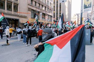 Filistinlilerin Gazze 'deki İsrail saldırısına karşı Toronto' da savaş karşıtı yürüyüş. İsrail-HAMAS savaşını barışçıl bir şekilde protesto ediyor. Protestocular bayrak sallıyor. Filistin soykırımı.