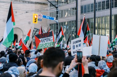 Filistinlilerin Gazze 'deki İsrail saldırısına karşı Toronto' da savaş karşıtı yürüyüş. İsrail-HAMAS savaşını barışçıl bir şekilde protesto ediyor. Protestocular bayrak sallıyor. Filistin soykırımı.