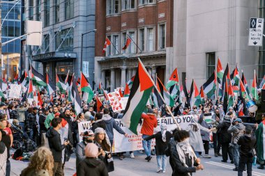 Filistinlilerin Gazze 'deki İsrail saldırısına karşı Toronto' da savaş karşıtı yürüyüş. İsrail-HAMAS savaşını barışçıl bir şekilde protesto ediyor. Protestocular bayrak sallıyor. Filistin soykırımı.