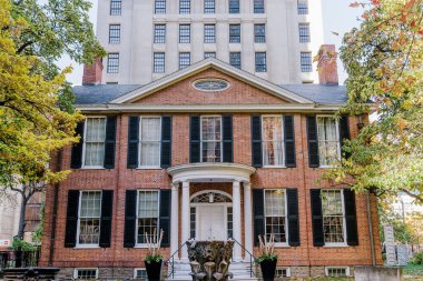 Modern bir gökdelene karşı klasik görünüşlü zarif tuğladan bir malikane. Etrafı gür ağaçlarla çevrili olan bina, tarihi mimarinin karışımını sergiliyor. Yüksek kalite fotoğraf