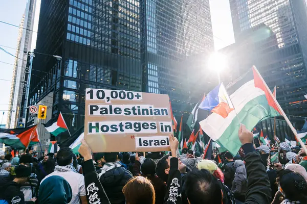 Filistinlilerin Gazze 'deki İsrail saldırısına karşı Toronto' da savaş karşıtı yürüyüş. İsrail-HAMAS savaşını barışçıl bir şekilde protesto ediyor. Protestocular bayrak sallıyor. Filistin soykırımı.