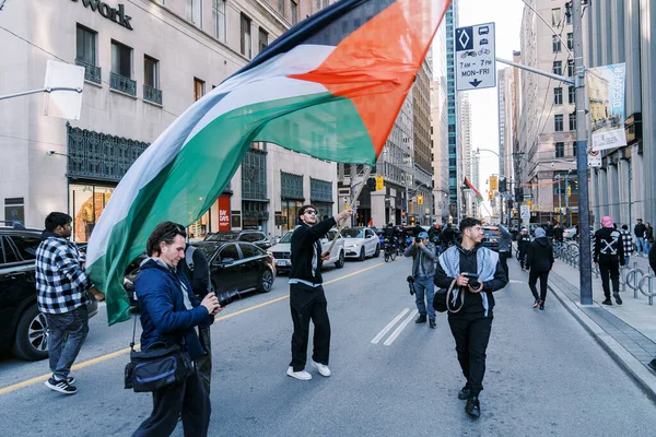 Filistinlilerin Gazze 'deki İsrail saldırısına karşı Toronto' da savaş karşıtı yürüyüş. İsrail-HAMAS savaşını barışçıl bir şekilde protesto ediyor. Protestocular bayrak sallıyor. Filistin soykırımı.