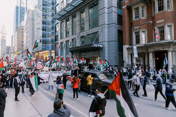 Filistinlilerin Gazze 'deki İsrail saldırısına karşı Toronto' da savaş karşıtı yürüyüş. İsrail-HAMAS savaşını barışçıl bir şekilde protesto ediyor. Protestocular bayrak sallıyor. Filistin soykırımı.