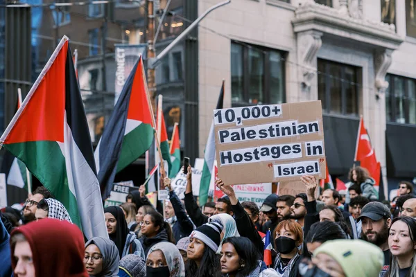 Filistinlilerin Gazze 'deki İsrail saldırısına karşı Toronto' da savaş karşıtı yürüyüş. İsrail-HAMAS savaşını barışçıl bir şekilde protesto ediyor. Protestocular bayrak sallıyor. Filistin soykırımı.