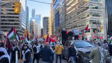 Filistinlilerin Gazze 'deki İsrail saldırısına karşı Toronto' da savaş karşıtı yürüyüş. İsrail-HAMAS savaşını barışçıl bir şekilde protesto ediyor. Protestocular bayrak sallıyor. Filistin soykırımı.