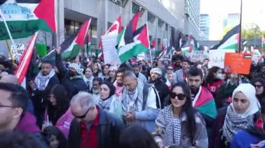Filistinlilerin Gazze 'deki İsrail saldırısına karşı Toronto' da savaş karşıtı yürüyüş. İsrail-HAMAS savaşını barışçıl bir şekilde protesto ediyor. Protestocular bayrak sallıyor. Filistin soykırımı.