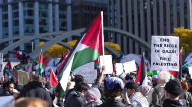 Filistinlilerin Gazze 'deki İsrail saldırısına karşı Toronto' da savaş karşıtı yürüyüş. İsrail-HAMAS savaşını barışçıl bir şekilde protesto ediyor. Protestocular bayrak sallıyor. Filistin soykırımı.