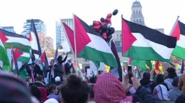Filistinlilerin Gazze 'deki İsrail saldırısına karşı Toronto' da savaş karşıtı yürüyüş. İsrail-HAMAS savaşını barışçıl bir şekilde protesto ediyor. Protestocular bayrak sallıyor. Filistin soykırımı.