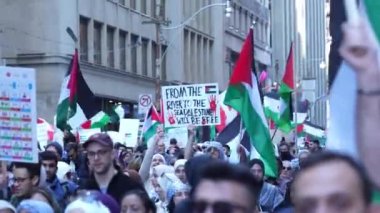 Filistinlilerin Gazze 'deki İsrail saldırısına karşı Toronto' da savaş karşıtı yürüyüş. İsrail-HAMAS savaşını barışçıl bir şekilde protesto ediyor. Protestocular bayrak sallıyor. Filistin soykırımı.
