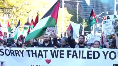 Filistinlilerin Gazze 'deki İsrail saldırısına karşı Toronto' da savaş karşıtı yürüyüş. İsrail-HAMAS savaşını barışçıl bir şekilde protesto ediyor. Protestocular bayrak sallıyor. Filistin soykırımı.