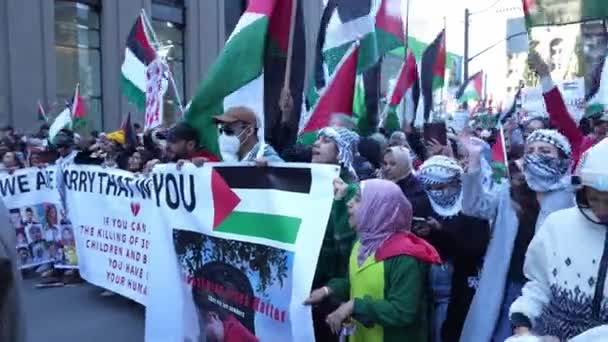 ガザでのイスラエルの侵略に対するパレスチナ人によるトロントでの反戦行進 イスラエル ハマス戦争に対する平和的な抗議 抗議者たちは反旗を掲げている パレスチナ人虐殺 — ストック動画