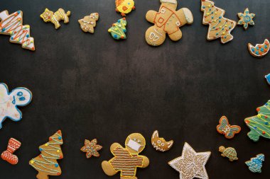 Glazed gingerbread ornament spread around the edges on a black background. High quality photo clipart