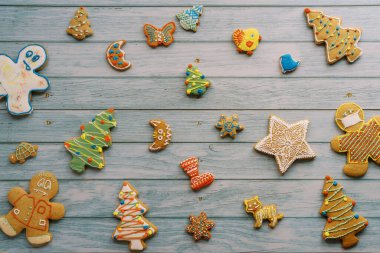 Renkli zencefilli kurabiyeler pembe ve mavi ahşap arka planda yatar. Yüksek kalite fotoğraf