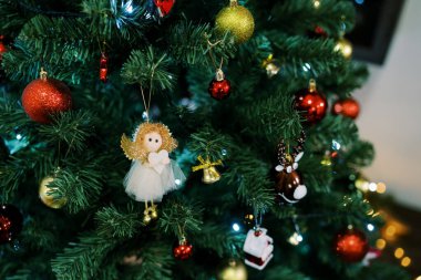 Kırmızı ve sarı topların arasındaki melek heykeli bir Noel ağacına asılı. Yüksek kalite fotoğraf