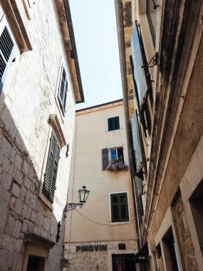 Dar bir sokakta eski bir evin penceresinde saksılar açıyor. Yüksek kalite fotoğraf