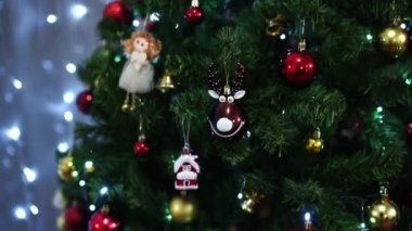 Noel ağacı, odada melek, geyik ve top heykelcikleri ile süslenir. Yüksek kalite 4k görüntü