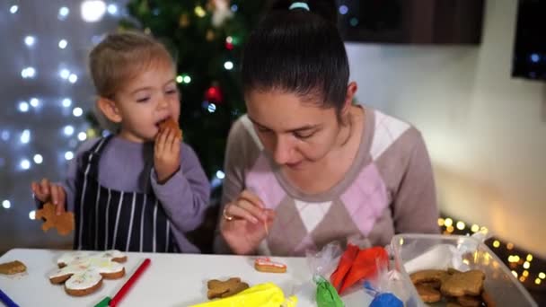 Petite Fille Mange Des Biscuits Tout Regardant Maman Décorer Les — Video