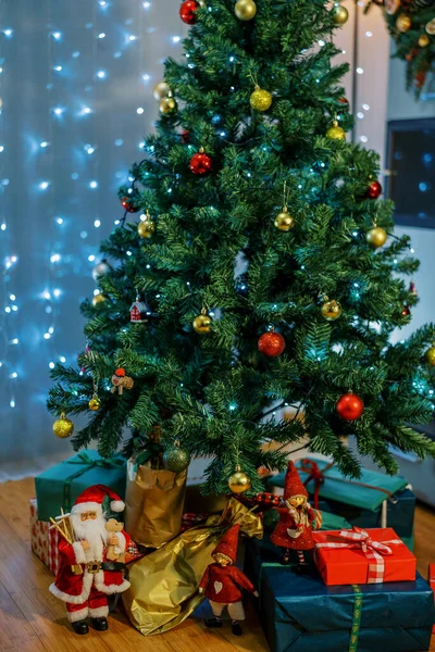 Noel ağacı Noel Baba ve elflerin hediyeleri ve heykelcikleriyle süslenmiş. Yüksek kalite fotoğraf