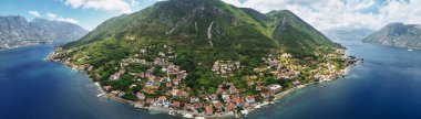 Yeşil bir dağın yamacında, deniz kıyısında kırmızı çatıları olan eski evler. Karadağ. Drone. Panorama. Yüksek kalite fotoğraf