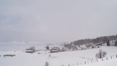 Kışın kar altında, ormanın kıyısındaki küçük bir köy. Yüksek kalite 4k görüntü