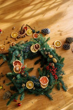 Süslü Noel çelengi yerde kurumuş meyve ve köknar kozalaklarıyla çevrili. Üst Manzara. Yüksek kalite fotoğraf