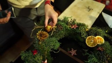 Kadın yılbaşı çelengine yapıştırıcı tabancasıyla süsleme yapıyor. Yüksek kalite 4k görüntü