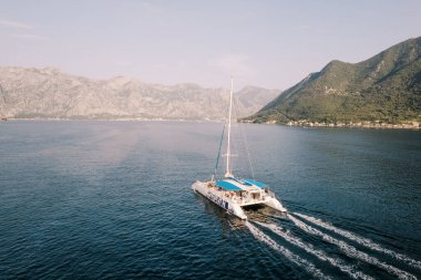 Dağlar boyunca denizde yüzen büyük yolcu katamaran yelkenlisi. Drone. Yüksek kalite fotoğraf