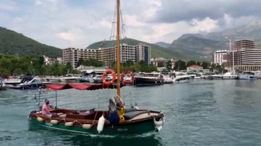 Keşif teknesi rıhtımdan ayrılıyor ve dağların eteğindeki körfez boyunca yüzüyor. Yüksek kalite 4k görüntü