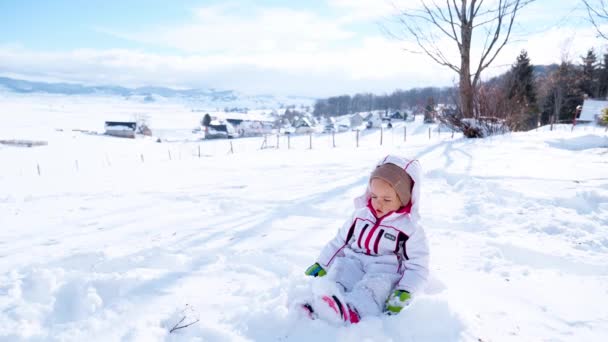 Menina Macacão Senta Neve Balança Pernas Imagens Alta Qualidade — Vídeo de Stock