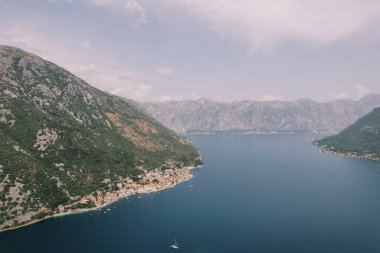 Arka planda Perast kıyısı olan Kotor Körfezi boyunca yelken açan yat. Karadağ. Hava görüntüsü. Yüksek kalite fotoğraf