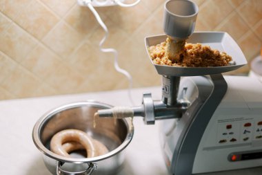 Hortumunda bağırsak yarası olan elektrikli et öğütücü ve tepside kıyma var. Yüksek kalite fotoğraf