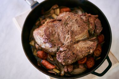 Kızartma tavasındaki haşlanmış sebzelerin üzerinde sulu biftek var. Üst Manzara. Yüksek kalite fotoğraf