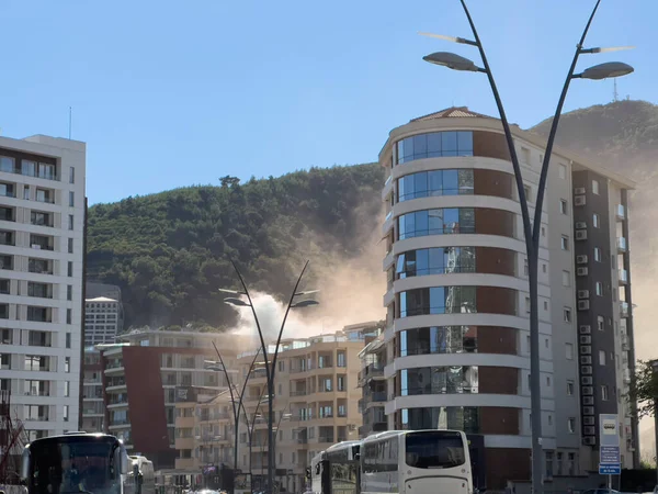 Dağların eteğindeki çok katlı bir binanın üzerindeki yangından çıkan yoğun duman. Yüksek kalite fotoğraf