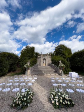 Beyaz sandalyeler, antik bir kilisenin merdivenlerinin yanında heykel ile düzenlenir. Yüksek kalite fotoğraf