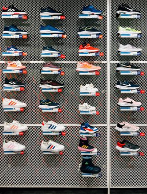 Mağazadaki raflarda çok renkli spor ayakkabılar var. Yüksek kalite fotoğraf