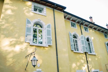 Eski bir malikanenin çatısının altındaki dikdörtgen küçük parmaklıklı pencereler. Yüksek kalite fotoğraf