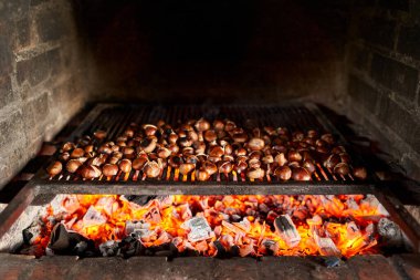 Kahverengi kestaneler ızgarada kızgın kömürde kızartılır. Yüksek kalite fotoğraf